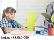 Улыбающаяся школьница весело смотрит в экран видеоурок в планшетном компьютере. Стоковое фото, фотограф Иванов Алексей / Фотобанк Лори