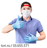 Deliveryman wearing plastic glasses, medical mask and blue neoprene gloves showing thumb up sign, isolated on white background. Стоковое фото, фотограф Кекяляйнен Андрей / Фотобанк Лори