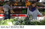 Female shopper picks onions at grocery store. Стоковое видео, видеограф Яков Филимонов / Фотобанк Лори