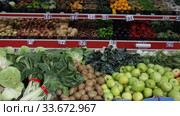 Large assortment of fresh colorful fruits and vegetables in wicker trays on shelves in supermarket. Стоковое видео, видеограф Яков Филимонов / Фотобанк Лори