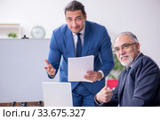 Yound and old employees in business presentation concept. Стоковое фото, фотограф Elnur / Фотобанк Лори