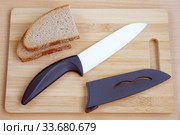 Ceramic knive on a chopping board. Стоковое фото, фотограф Демьянович Вадим / Фотобанк Лори