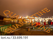 Coronavirus in Prague, Czech Republic. Embankment of the Vltava River near Charles Bridge. Quarantine sign on a blurred background. Concept of COVID pandemic and travel in Europe. (2019 год). Стоковое фото, фотограф Владимир Журавлев / Фотобанк Лори