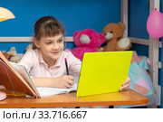 Девочка в детской комнате сидит за столом и учится онлайн. Стоковое фото, фотограф Иванов Алексей / Фотобанк Лори