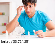 Man trying contact lenses at home. Стоковое фото, фотограф Elnur / Фотобанк Лори