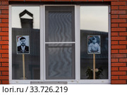 Россияне ставят портреты родственников, участников Великой Отечественной война в окна домов, в городе Волоколамск Московской области в рамках акции "Бессмертный полк" в день 75-й годовщины Победы в Великой Отечественной войне, в период самоизоляции и эпидемии коронавируса COVID-19 в России (2020 год). Редакционное фото, фотограф Николай Винокуров / Фотобанк Лори