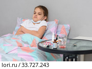 Девочка лежит в кровати и не желает принимать лекарственные средства. Стоковое фото, фотограф Иванов Алексей / Фотобанк Лори