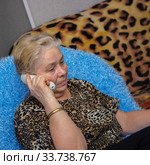 Elderly  beautiful woman talking on the phone at home. Стоковое фото, фотограф Александр Романов / Фотобанк Лори