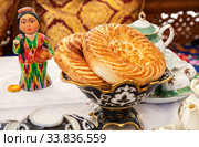 Fresh uzbek flatbread with sesame seeds on the holiday table (2019 год). Редакционное фото, фотограф FotograFF / Фотобанк Лори