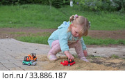 Little girl playing with toy cars in sandbox. Редакционное видео, видеограф Сергей Старуш / Фотобанк Лори