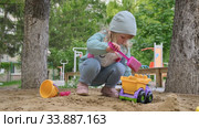 Little girl playing with toy car in sandbox. Редакционное видео, видеограф Сергей Старуш / Фотобанк Лори