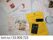 Коммунальные платежи. Квитанции, деньги и калькулятор и лупа. Стоковое фото, фотограф Кузнецов Максим / Фотобанк Лори
