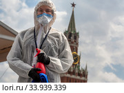 Волонтер во время проведения дезинфекции на ежегодном книжном фестивале "Красная площадь" в центре города Москвы во время эпидемии коронавируса COVID-19 в России (2020 год). Редакционное фото, фотограф Николай Винокуров / Фотобанк Лори