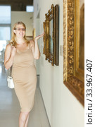 Woman wearing glasses looking at pictures. Стоковое фото, фотограф Яков Филимонов / Фотобанк Лори