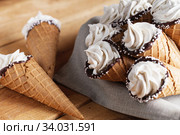 A lot of ice cream cones on wooden table. Soft ice creams or frozen custard in cones. Waffle marshmallows. Стоковое фото, фотограф Nataliia Zhekova / Фотобанк Лори
