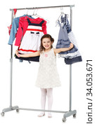 Little fashionable girl chooses clothes in a wardrobe. Стоковое фото, фотограф Nataliia Zhekova / Фотобанк Лори