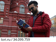 Иностранец держит в руках брошюру конституции Российской Федерации (2020 год). Редакционное фото, фотограф Кузнецов Максим / Фотобанк Лори
