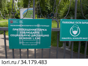 Табличка "Соблюдайте дистанцию" у входа в парк. Москва (2020 год). Редакционное фото, фотограф Елена Орлова / Фотобанк Лори