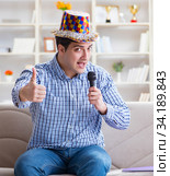 Funny man singing songs in karaoke at home. Стоковое фото, фотограф Elnur / Фотобанк Лори