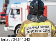 Back view of inscription Emercom of Russia on uniform firefighter of Ministry of Civil Defence, Emergencies and Disaster Relief of Russian Federation MChS (2019 год). Редакционное фото, фотограф А. А. Пирагис / Фотобанк Лори