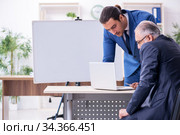 Yound and old employees in business presentation concept. Стоковое фото, фотограф Elnur / Фотобанк Лори