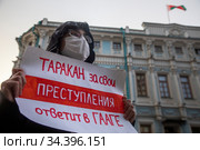 Парень держит плакат против правления президента Беларуси на фоне здания посольства Республики Беларусь в Москве, Россия (2020 год). Редакционное фото, фотограф Николай Винокуров / Фотобанк Лори