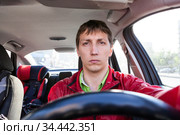 Front view at male driver sitting close to steering wheel in car, man driving a vehicle. Стоковое фото, фотограф Кекяляйнен Андрей / Фотобанк Лори