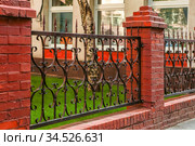 Brick and metal fence in Moscow (2014 год). Стоковое фото, фотограф Юлия Стусь / Фотобанк Лори