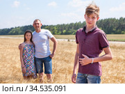 Handsome boy portrait with his father and preteen sister on background, Caucasian family in wheat field. Стоковое фото, фотограф Кекяляйнен Андрей / Фотобанк Лори