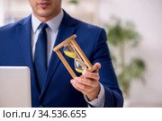 Young male employee in time management concept. Стоковое фото, фотограф Elnur / Фотобанк Лори