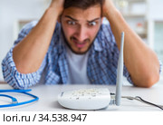 Frustrated young man due to weak internet reception. Стоковое фото, фотограф Elnur / Фотобанк Лори