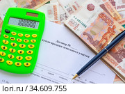 На договоре купли продажи земельного участка лежат калькулятор, пачка денег и ручка. Стоковое фото, фотограф Иванов Алексей / Фотобанк Лори