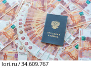 На пятитысячных российских купюрах лежит трудовая книжка. Стоковое фото, фотограф Иванов Алексей / Фотобанк Лори