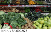 Large assortment of fresh colorful fruits and vegetables in wicker trays on shelves in supermarket. Стоковое видео, видеограф Яков Филимонов / Фотобанк Лори