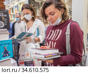 Посетители Московской международной книжной ярмарки знакомятся с новинками (2020 год). Редакционное фото, фотограф Сайганов Александр / Фотобанк Лори