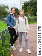 Pre-teen girl a student in grade 6 goes back to school at September, full-length portrait with mother outdoor. Стоковое фото, фотограф Кекяляйнен Андрей / Фотобанк Лори