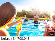 Two teen girls in swimming pool shooting water-gun. Стоковое фото, фотограф Сергей Новиков / Фотобанк Лори