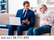 Young male lawyer visiting old man in testament concept. Стоковое фото, фотограф Elnur / Фотобанк Лори