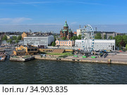 Хельсинки, Финляндия. Городской пейзаж с Успенским православным соборм и колесом обозрения. Вид с открытой палубы парома (2019 год). Редакционное фото, фотограф Михаил Марковский / Фотобанк Лори