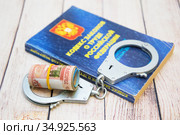 Кодекс законов о труде Российской Федерации, деньги и наручники. Соблюдение трудового законодательства. Стоковое фото, фотограф Наталья Осипова / Фотобанк Лори