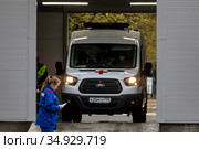 Машина скорой медицинской помощи проходит дезинфекцию во временном лечебном комплексе конгрессно-выставочного центра «Сокольники» для пациентов новой коронавирусной инфекции в городе Москве, Россия (2020 год). Редакционное фото, фотограф Николай Винокуров / Фотобанк Лори