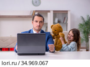 Girl bothering young father during working from house in pandemi. Стоковое фото, фотограф Elnur / Фотобанк Лори