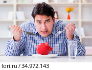 Man running out of money in restaurant and using savings from pi. Стоковое фото, фотограф Elnur / Фотобанк Лори