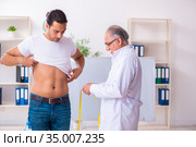 Doctor dietician giving advices to fat overweight patient. Стоковое фото, фотограф Elnur / Фотобанк Лори