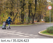 Москва, ВДНХ. Рабочий в синей форменной куртке везет мусорный контейнер под дорожный знак "Движение запрещено" (2020 год). Стоковое фото, фотограф Наталья Николаева / Фотобанк Лори