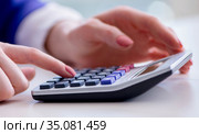 Hands working on accounting calculator calculating profit. Стоковое фото, фотограф Elnur / Фотобанк Лори