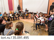 Classical music concert for parents is in Russian children academy of music. Boys and girls with adults play quitar together (2020 год). Редакционное фото, фотограф Кекяляйнен Андрей / Фотобанк Лори