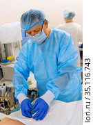 Doctor inserts double lumen catheter in jugular vein. Стоковое фото, фотограф Beerkoff / Фотобанк Лори