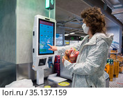 Покупатель у кассы самообслуживания в магазине "Пятерочка" (2020 год). Редакционное фото, фотограф Вячеслав Палес / Фотобанк Лори