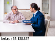 Young male lawyer visiting old man in testament concept. Стоковое фото, фотограф Elnur / Фотобанк Лори